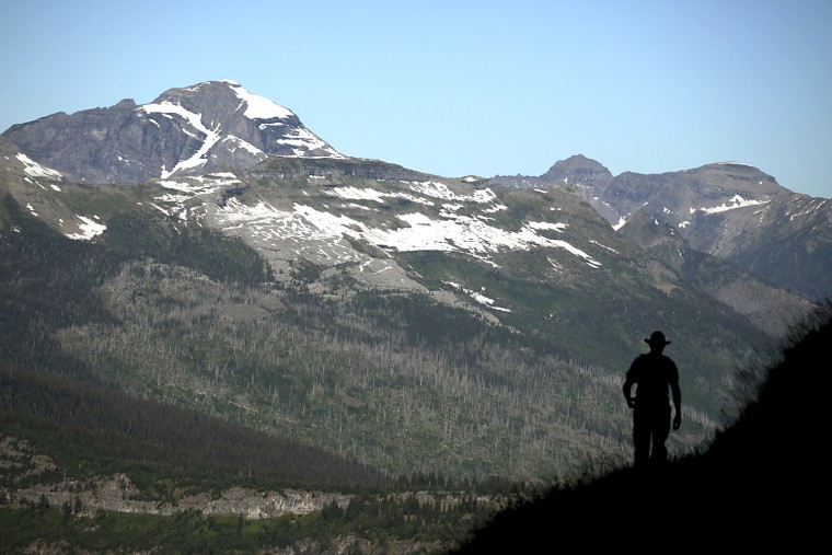 Image: Nick Wieland of Eagan, Minnesota hikes the Highline Trail with a view of Heaven's Peak in Glacier National Park, Montana